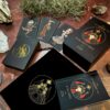 The Guidance of the Goddess Oracle set is elegantly packaged with illustrated goddess cards in a box and a black pouch featuring a gold emblem, artfully arranged with stones and dry twigs for enhanced mystical allure.