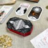 A spread of oracle cards from The Citadel Oracle - LE Boxed Set, featuring "The Weaver" and "The Astronomer," is beautifully displayed among crystals and mystical items on a textured beige table.