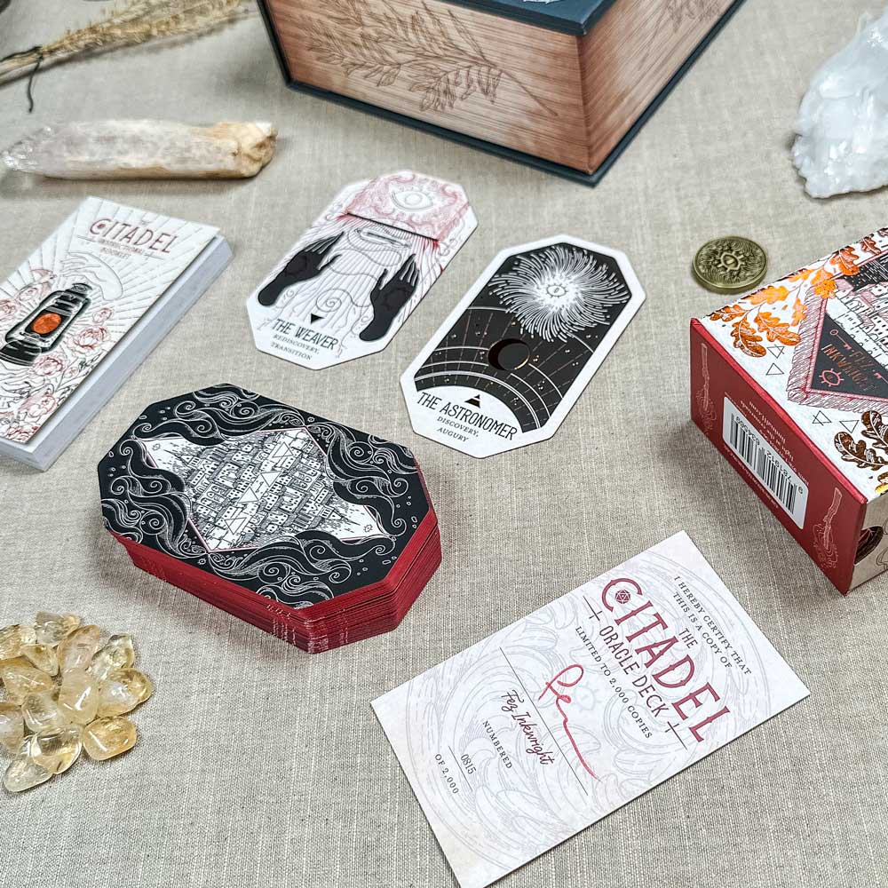 The Citadel Oracle - LE Boxed Set adorns the table, its cards like "The Weaver" and "The Astronomer" displayed among crystals and a coin, creating an enchanting ambiance.